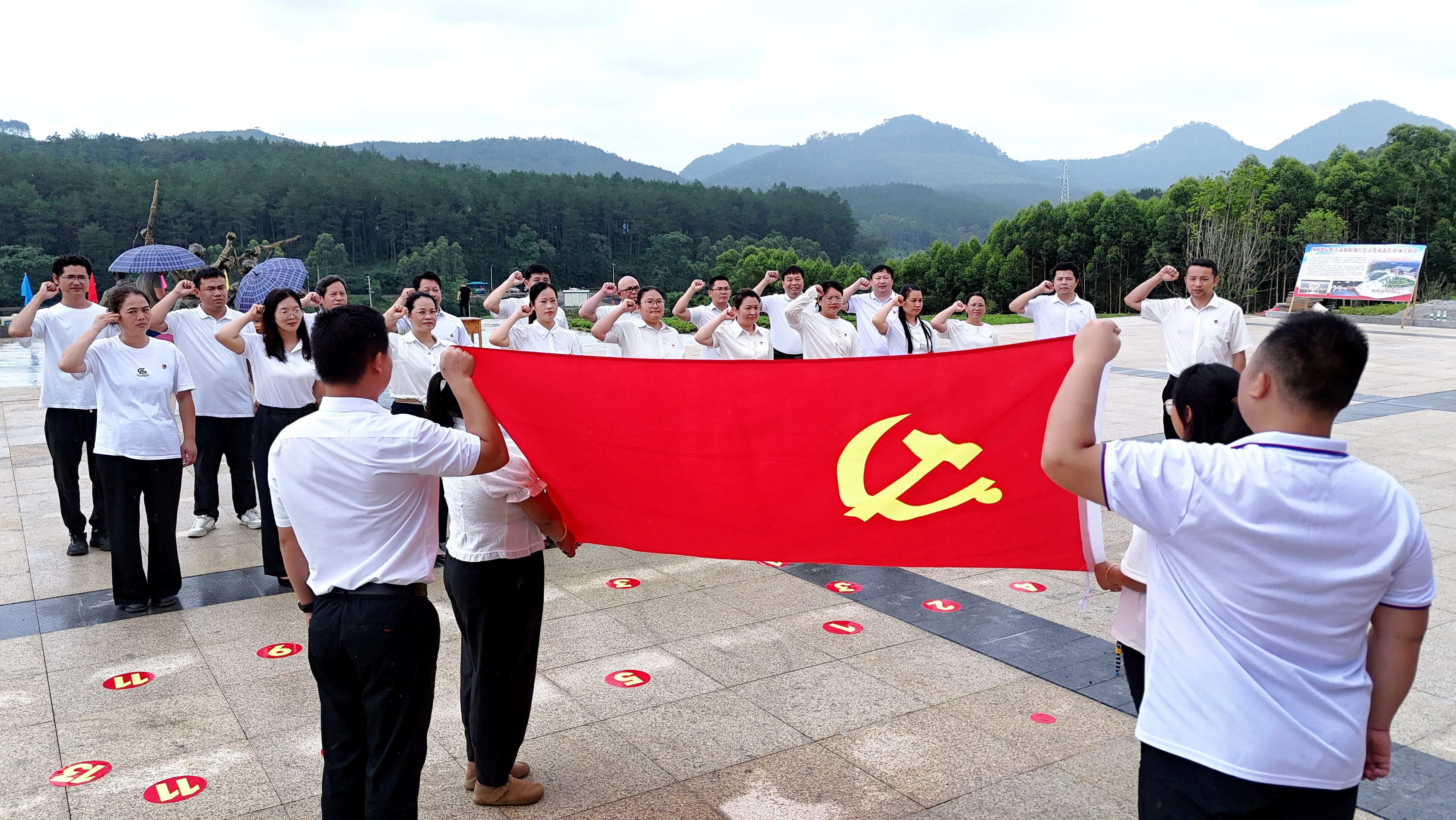 2025年7月1日，广西都宜忻人民解放总队纪念馆前，党员面向党旗重温入党誓词。